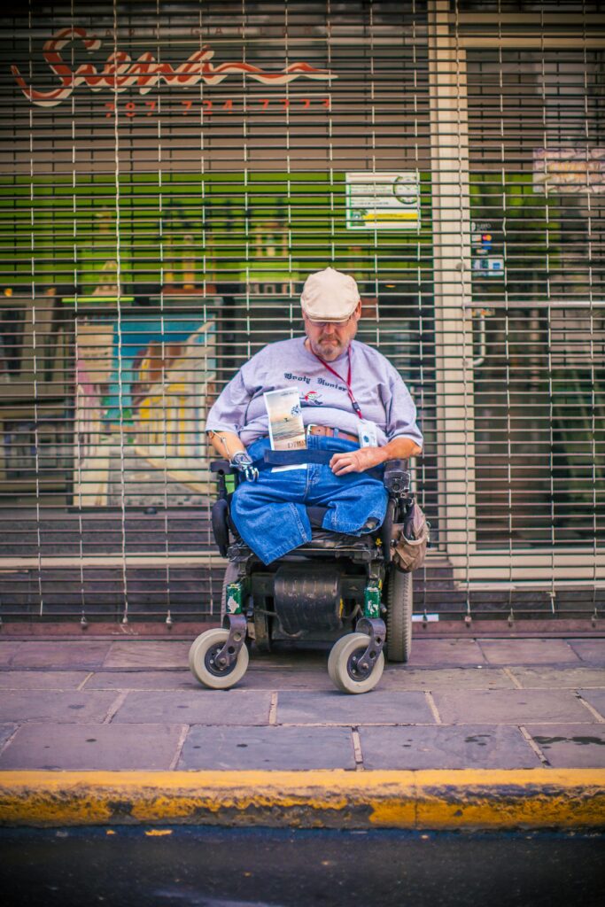 Man Sitting on Black and Green Power Wheelchair